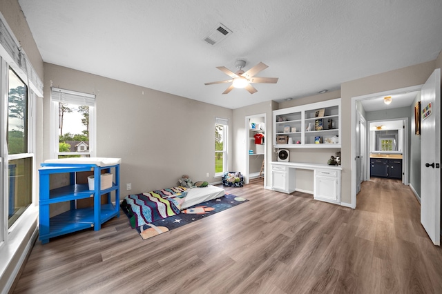 miscellaneous room featuring ceiling fan, plenty of natural light, built in shelves, and built in desk