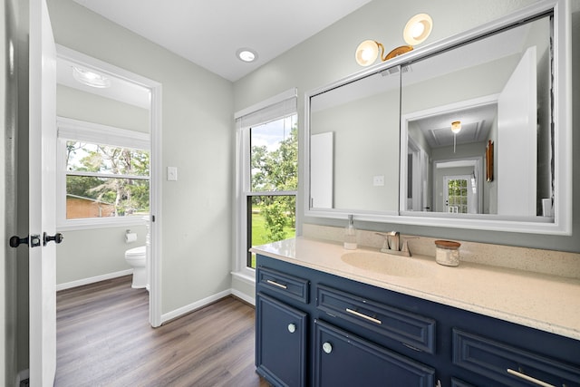 bathroom featuring toilet, hardwood / wood-style floors, and vanity