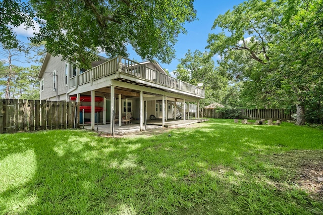 rear view of property with a wooden deck, a patio, and a yard