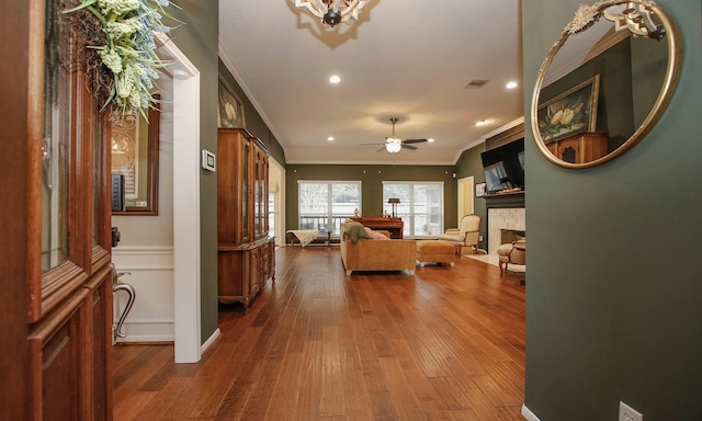 living room featuring ceiling fan, ornamental molding, and hardwood / wood-style flooring