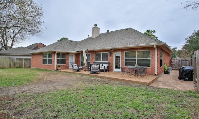 rear view of property featuring a wooden deck and a yard