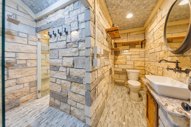 bathroom with toilet, brick ceiling, hardwood / wood-style flooring, lofted ceiling, and vanity