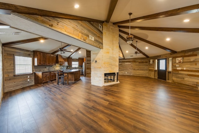 living room featuring dark wood-type flooring, ceiling fan, and beamed ceiling