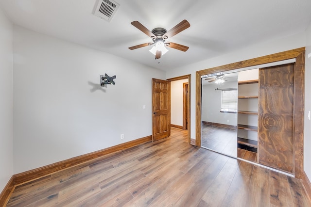 unfurnished bedroom with ceiling fan, hardwood / wood-style floors, and a closet