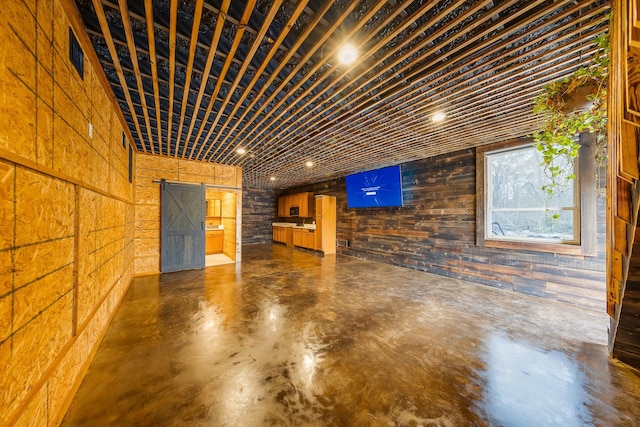 interior space with a barn door and wooden walls