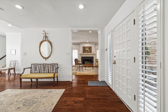 foyer entrance featuring dark hardwood / wood-style floors and a fireplace