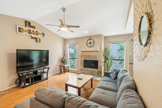 living room featuring ceiling fan, lofted ceiling, a fireplace, and hardwood / wood-style floors