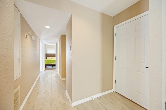 corridor with light hardwood / wood-style floors