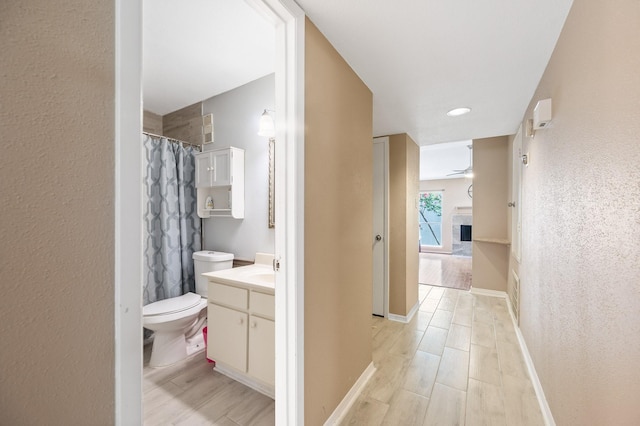 bathroom with ceiling fan, vanity, toilet, and hardwood / wood-style floors