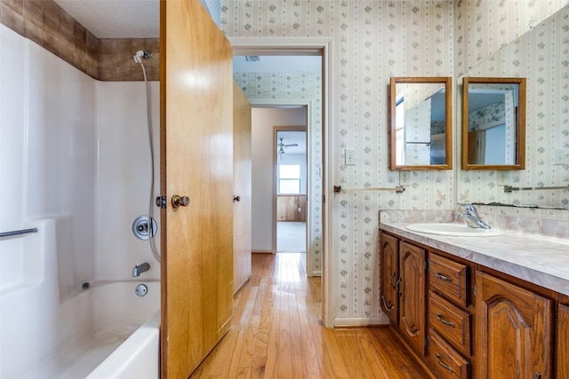 bathroom featuring  shower combination, hardwood / wood-style floors, and vanity