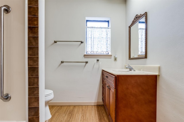 bathroom featuring toilet, hardwood / wood-style flooring, and vanity