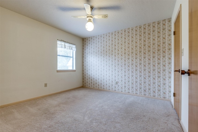 spare room featuring ceiling fan, light carpet, and a textured ceiling