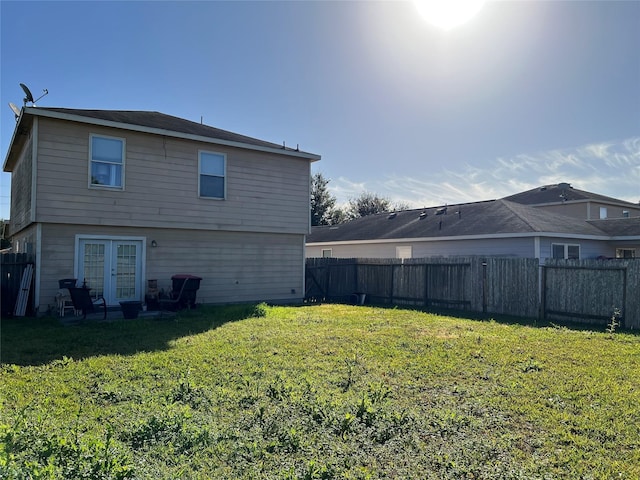 back of house featuring french doors and a yard