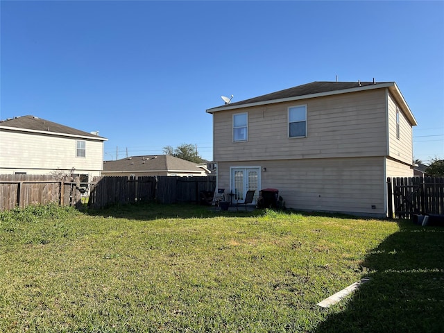 rear view of house with french doors and a yard