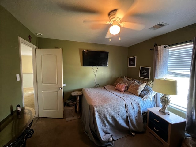 carpeted bedroom with ceiling fan and multiple windows