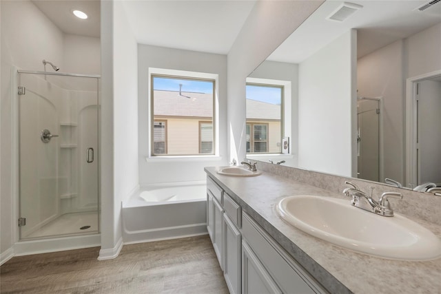 bathroom with hardwood / wood-style floors, vanity, and independent shower and bath