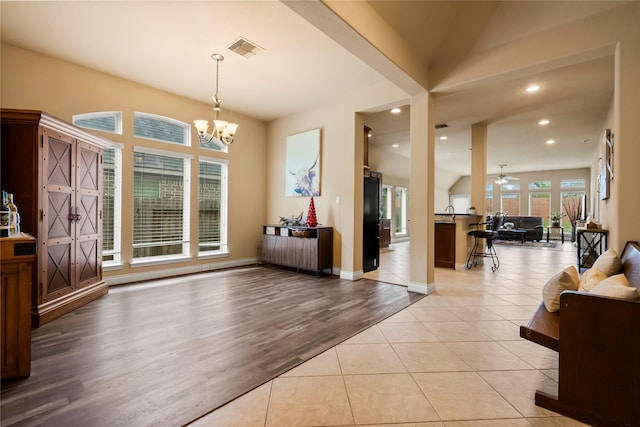 interior space featuring ceiling fan with notable chandelier