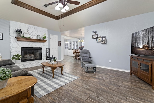 living room with a high ceiling, a fireplace, ceiling fan with notable chandelier, and ornamental molding