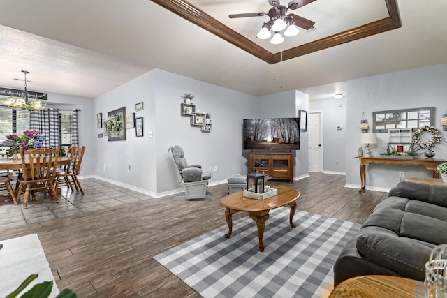 living room featuring vaulted ceiling, crown molding, ceiling fan with notable chandelier, and dark hardwood / wood-style floors