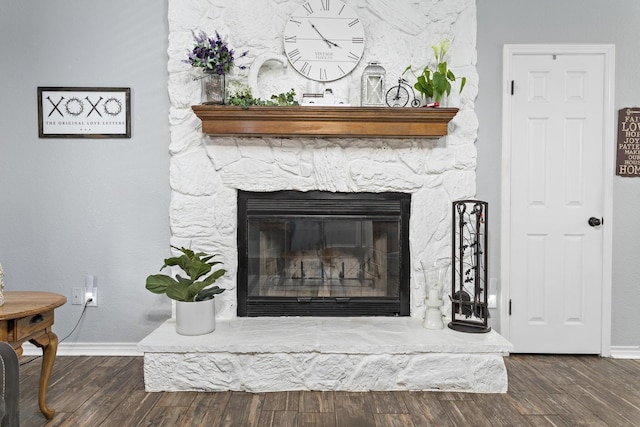 interior details featuring hardwood / wood-style floors and a stone fireplace