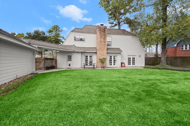 back of house featuring a lawn, french doors, and a patio