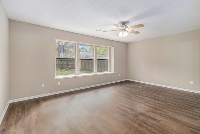 empty room featuring ceiling fan, a textured ceiling, and dark hardwood / wood-style flooring