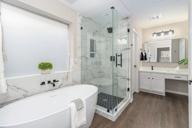 bathroom with vanity, wood-type flooring, a textured ceiling, and shower with separate bathtub