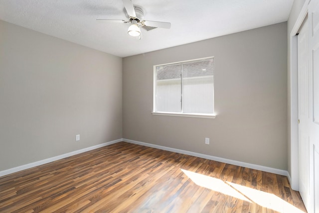 empty room with ceiling fan and dark hardwood / wood-style floors