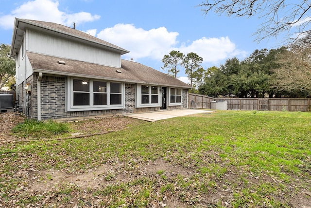 back of house with central AC unit, a lawn, and a patio