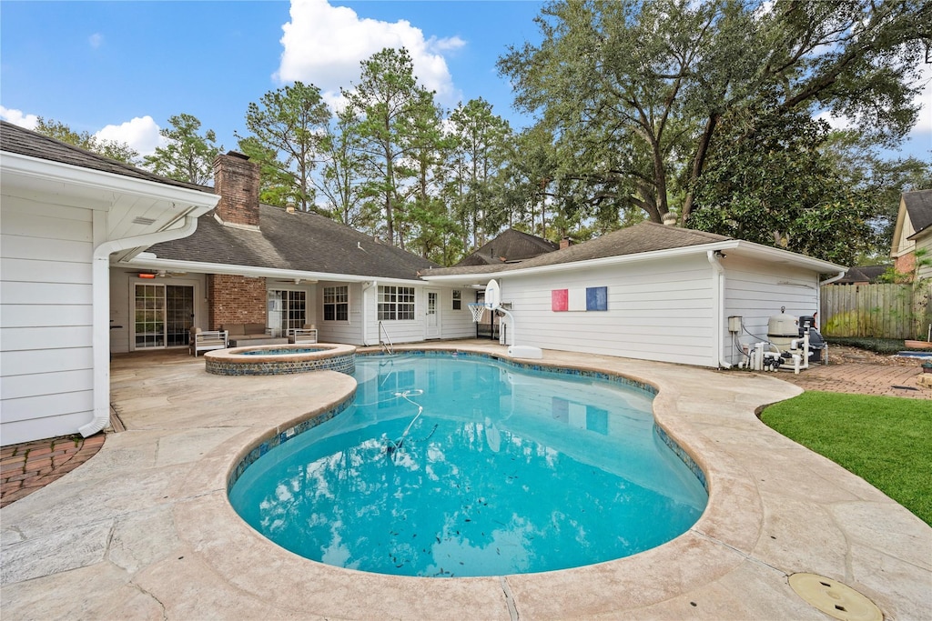 view of swimming pool featuring an in ground hot tub and a patio area