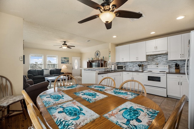 dining area featuring ceiling fan, sink, and light tile patterned floors