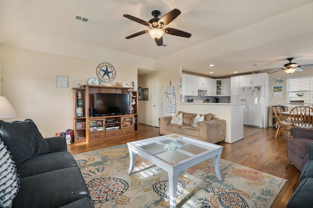 living room featuring ceiling fan and hardwood / wood-style flooring