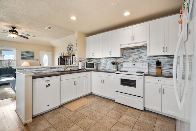 kitchen with kitchen peninsula, ceiling fan, white appliances, white cabinets, and sink