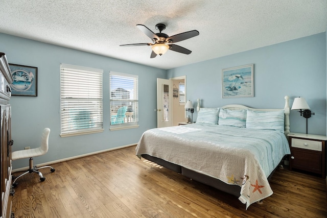 bedroom with a textured ceiling, ceiling fan, and hardwood / wood-style flooring