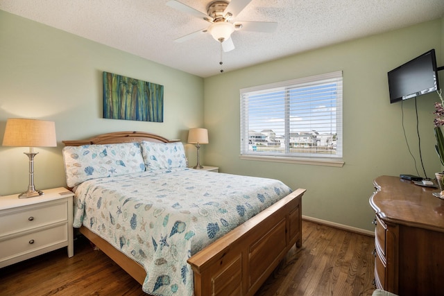 bedroom with a textured ceiling, ceiling fan, and dark hardwood / wood-style floors