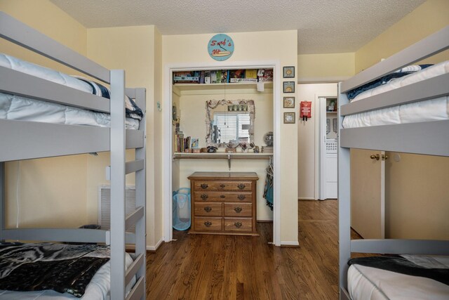 bedroom with dark wood-type flooring, a textured ceiling, and a closet