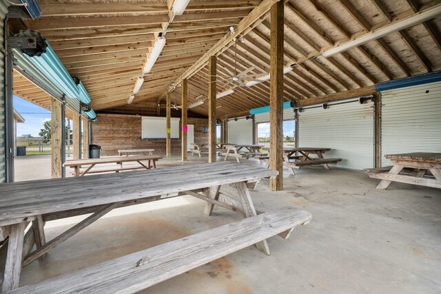 miscellaneous room featuring vaulted ceiling and concrete floors