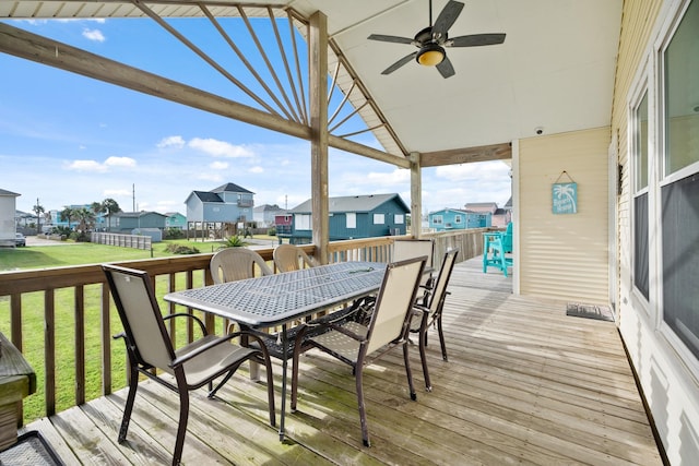 wooden terrace featuring ceiling fan and a yard