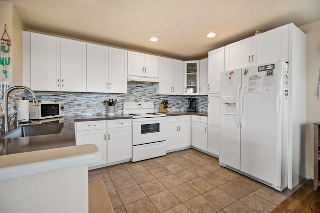 kitchen with light tile patterned floors, white cabinets, and white appliances