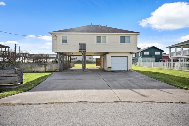 rear view of property with a garage, a yard, and a carport