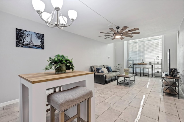 tiled living room with ceiling fan with notable chandelier