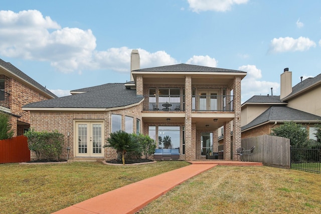 rear view of property with an outdoor hangout area, a yard, french doors, and a balcony