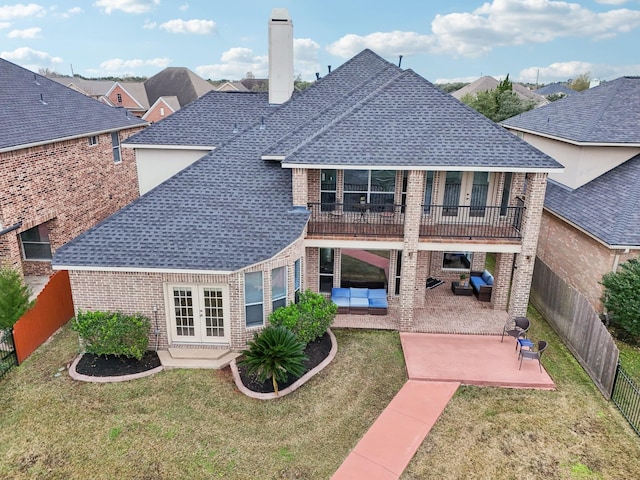 back of property with a lawn, french doors, outdoor lounge area, and a patio