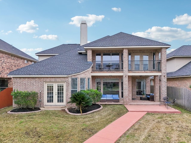 back of house with a yard, french doors, a balcony, and a patio