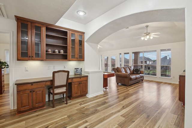 home office with ceiling fan, light hardwood / wood-style flooring, and built in desk