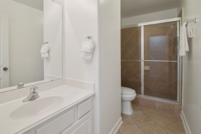 bathroom with an enclosed shower, vanity, toilet, and tile patterned flooring