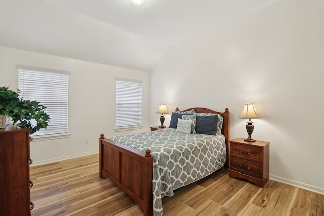 bedroom with vaulted ceiling and light hardwood / wood-style floors