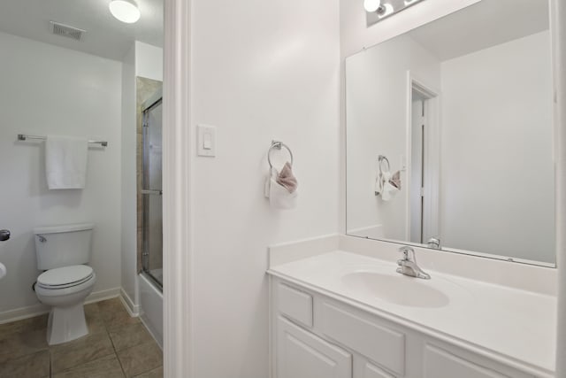 full bathroom featuring bath / shower combo with glass door, toilet, vanity, and tile patterned flooring