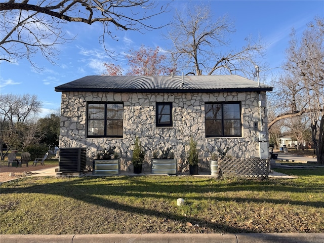 view of front of house with a front lawn and central AC unit