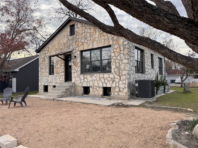 back of house with central AC unit and a patio